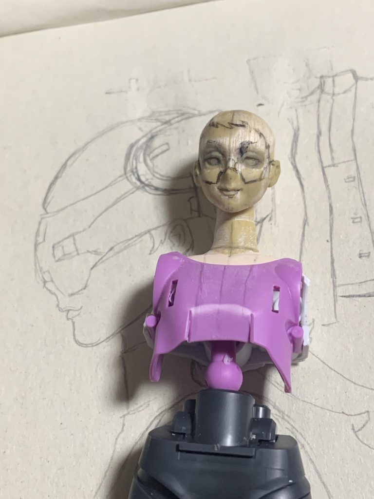 顔のパテ造形がだいたい済んだので、メットの位置合わせのための線を引いたところです。