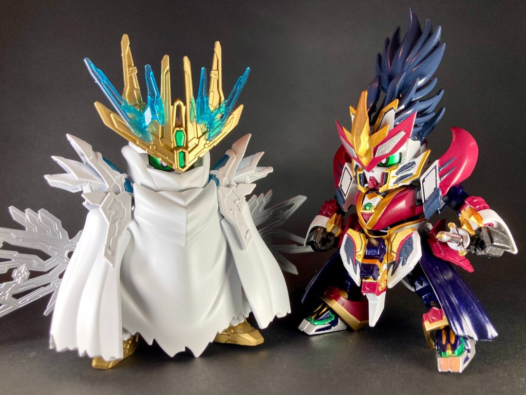 〜〜〜〜〜〜〜〜〜〜〜〜SDガンダムワールドヒーローズ第6話「魔王降臨」にて、アヅチ城下町の定食屋を訪れた曹操ウイングガンダムの前に現れた軽装姿の信長ガンダムエピオンを作りました。こちらのデザインいわゆるお忍びVer.は、第6話の数分間のみ登場でガンプラキット化等も展開されていないため、信長エピオンのバリエーションとしては若干マイナーな存在ですが、しっかり別デザインの軽装姿になっている事や、あの信長が一般客に紛れて昼間から定食屋のカウンターで酌を傾けている…という登場時の意外性も相まって大変印象に残っています。その後、アニメ放映終了後にX(Twitter)上で、創傑伝ヒーローズ作品のSDデザイン担当メカデザイナーの宮内利尚氏が、お忍びVer.の詳細なデザイン画稿を公開して下さるという嬉しいファンサービスがありました。従来の信長デザインとの共通点や相違点も丁寧に図示・解説して下さり、さらに「ガンプラを改造してお忍びVer.を作ってみよう！」とのお言葉も記載されていたので、これはもう作らせて頂くしかないと決意して今回の製作に至りました。