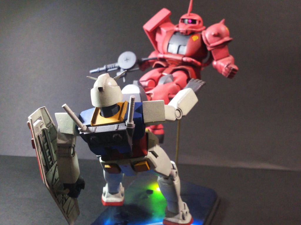 次にガンダムの主な改修は、顔の切り離し再接着。首の延長(頭が下向きになるように)、腰周りの延長(少しくの字になるように)、バックパック表面プラ板にてカサ増し、エネルギーパック市販パーツ(○一パーツ)貼り付け、バーニアも市販パーツを取り付けました。手は右手は旧キット 1/144 旧ザクの平手を流用、左手はキットパーツにエポパテを盛り少し大型化。楯は窓開口及び裏側にプラ板など貼り付けてディテールアップ。他、関節はアルミ線接続、一部接着固定しています。