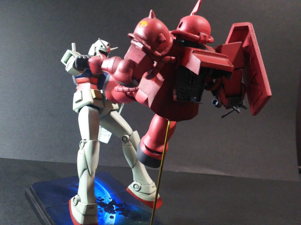 ベースは、100均のコレクションBOXの台座部を使用し、ネットから適当に気に入った宇宙空間の写真を印刷し、それを両面テープで台座に固定し、シャアザク、ガンダム共、真鍮線にて台座に固定しました。