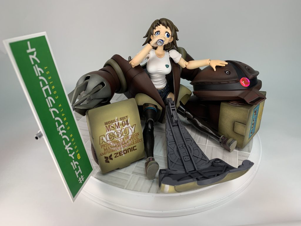 本体の文字類はマスキング切り抜き塗装と手描きです。アッガイ右手の緑のやつは、コンテストのレギュレーションで必須の応募用紙を看板化したものです。応募用紙も作品の一部にしてしまおう、みたいにこだわってみました。