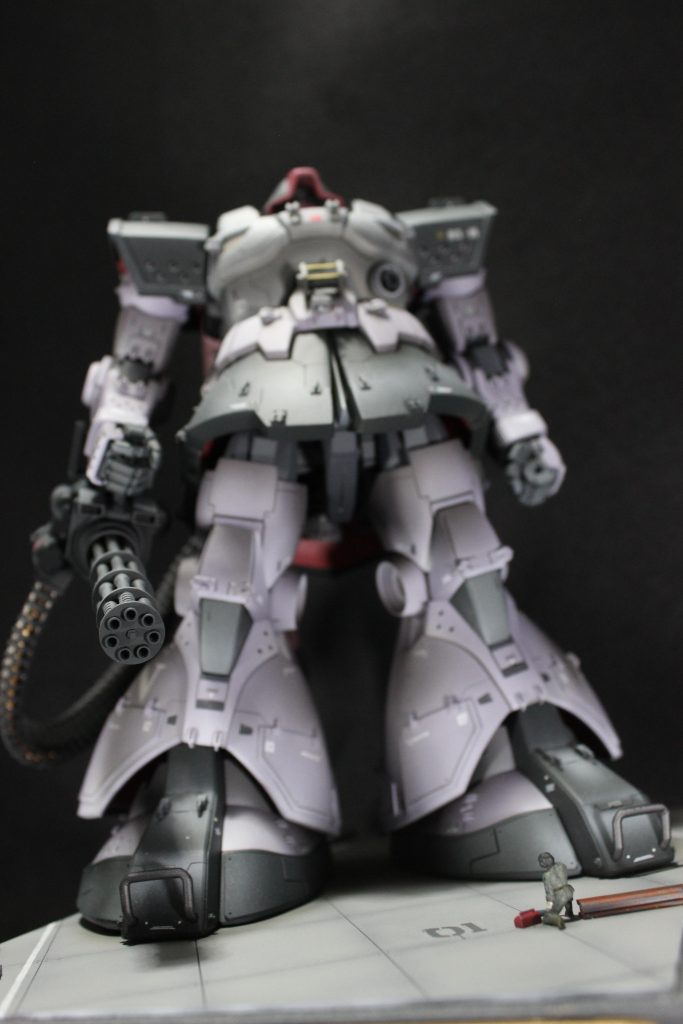 人目線での撮影です。人はMSフィギュア1/00の整備兵の腕を加工し、作業が終わって、MSを見上げながら一息ついてるような感じにしました。整備兵の周りの赤いのは工具箱(プラ棒をちょっとヤスって作りました。)、茶色いのは鉄骨(Hプラ棒を切りました。)です。
