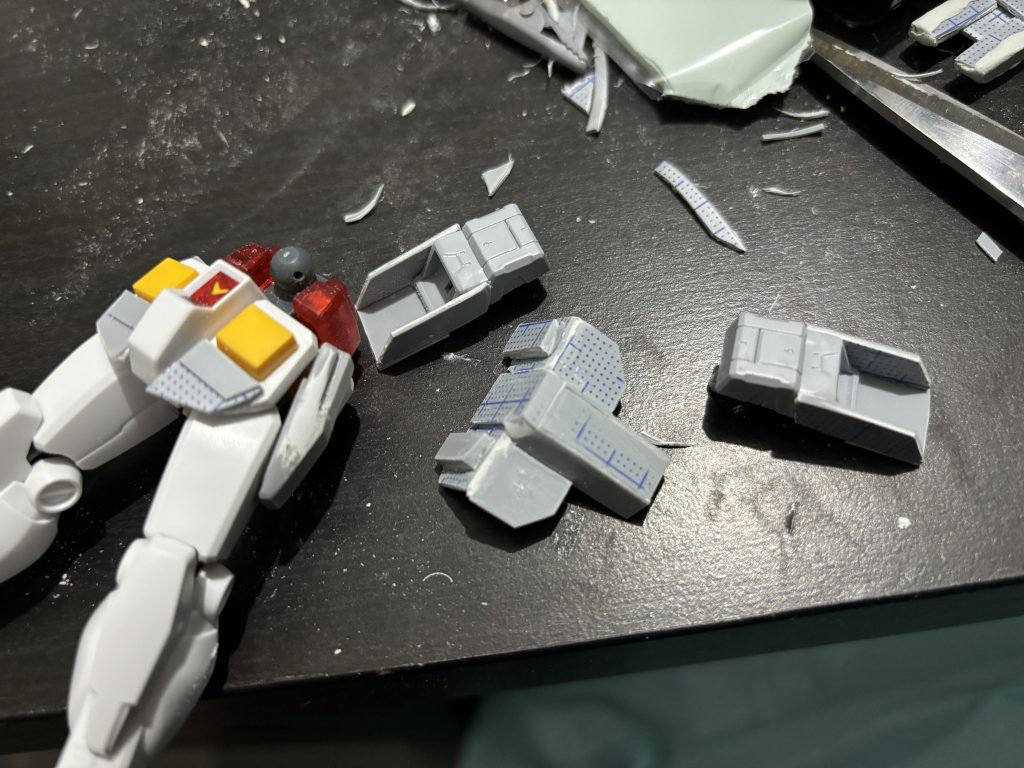 プラ板練習も兼ねて追加装甲を自作です。胸のアーマーは0.5mmと1mmプラ板を組み合わせて、3mmネオジム磁石本体裏とアーマーに仕込んでいます。ダクトはウェーブの物を使用。腰アーマーの前後はプラ板で長さを延長、腰のサイドアーマーはプラ板で延長した後にパテで埋めて形を慣らしています。脚部が寂しくなるので本体ふくらはぎ部分に穴を空けて、ビルダーパーツのバーニアを取り付けました。プラ板で長さを少し延長しています。余ったランナーを使って脱着可能にしています。