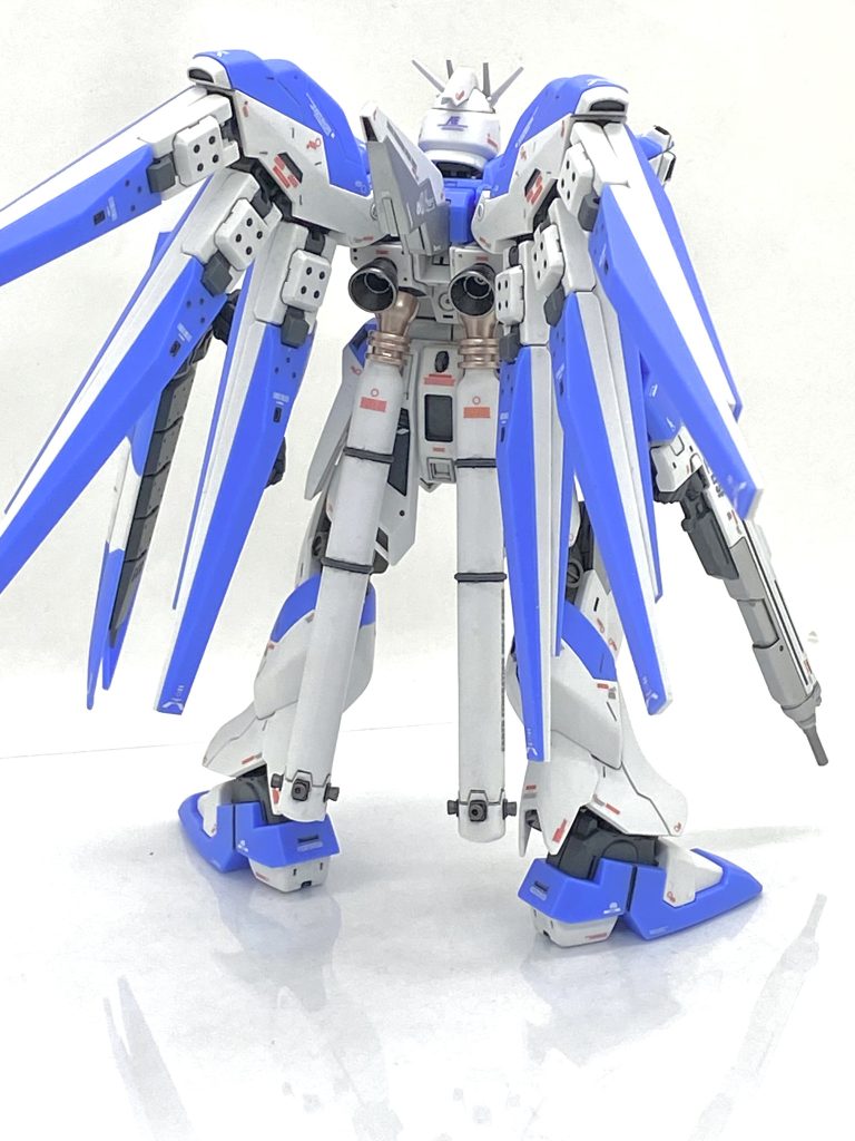 セイラマスオ先生のムック見て、まず思ったのは膝が干渉して足が真っ直ぐにならない事でここはルーターを使って干渉してる箇所をバリバリ削り、かなり真っ直ぐに立てる様になり素立ちが決まる様になりました。次は腕が胴体から離れ過ぎてる事でここも腕の軸の干渉している個所を削って腕の密着感を高めます。最後は顔で説明書だと目が大きく出ていてそれだとカッコ悪いから自分もマスオ先生と同じく顔をノコで切ってやや上に再接着すると細目で目つきが悪いVer.Ka風になりこれはハマりそうです(笑)。マスオ先生みたいに胴体の延長やタグを使ったディテール作りは自分がやれば必ず失敗しますからこれは自重しました(汗)。Xのフォロワー様には筆塗りの上手い方が多数いるので自分も負けない様に細かい凹ディテールはなるべくグレーで塗り分け、ファンネル基部やシールド裏、なんかのグレーやシルバーはエアブラシで塗っています。ガイアカラーのフラットシルバーは初めて使ったのですが艶消しのシルバーながらも上品で落ち着いた輝きがあり、Hi-νガンダムにピッタリの輝きだと思います。