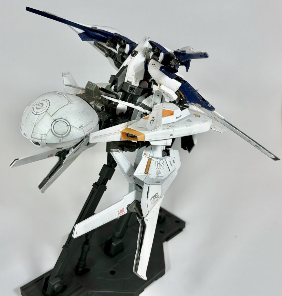 [NRX-124 DLf Ⅱ ダンディライアン・フラッフィⅡ MS形態]ウーンドウォート・エフラファにダンディライアン・フラッフィⅡをドッキングした形態。ダンディライアン・フラッフィⅡの上部装甲となっていた部分がそのまま大型のシールドとして機能するようになっている他、大型スラスターユニットの塊であるユニットを下半身に装備したことで、見た目の大きさに似合わない機動性を発揮することが可能となっている。また、機体後部に装備されたダイダロス・ルーユニットは簡易式のミノフスキークラフトとなっており、大気圏内においても稼働可能である。また、簡易式であるため、時間制限付きではあるものの、フル稼働させれば大気圏内を飛行することも可能である。GBNにおいては、主にその機動力と防御力を活かし、チャレンジミッションやレイドボス討伐戦などにおいて、切り込み役及びタンク役として運用される。