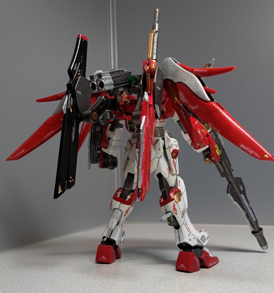 バックショットです。バックパックにF91で使ったフォールディングアームから、アームパーツの余りと折り畳み式ライフルの一部を装着しました。脹ら脛のスラスターは脚内部のボスを切除して可動範囲を広げています。また右前腕部のシールド取り付け穴はプラ棒とHアイズ(クリア)で埋めてイエローで塗りました。以下、アクションポーズです。