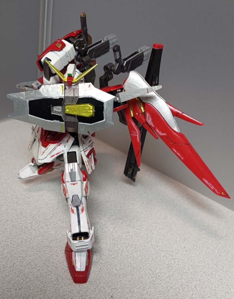 続いての追加武器、折り畳み式ライフルの一部と轟槍鬼十字のジョイントを組み合わせたフォールディングビームガンです。折り畳まれたグリップを立たせて上に向ければ、バックパックにマウントした状態で掴むことができます。微改造ポイントとして、前腕部の赤い手甲を好きな向きで取り付けられるように溝を腕一周ぶん彫っています。前回のF91のようにシールドを前面に構えるなどのポーズが可能になりました。