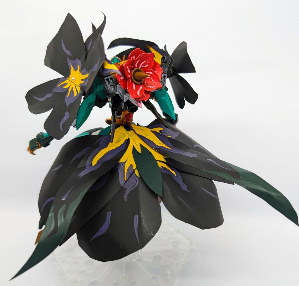 左肩の花は大きく右は小さい腰部〜下のスカートはビオラの花が分割され蝶の羽のような見た目になっている背部から頭部前まで花びらのようななにかが覆っているが厨二病要素のひとつ