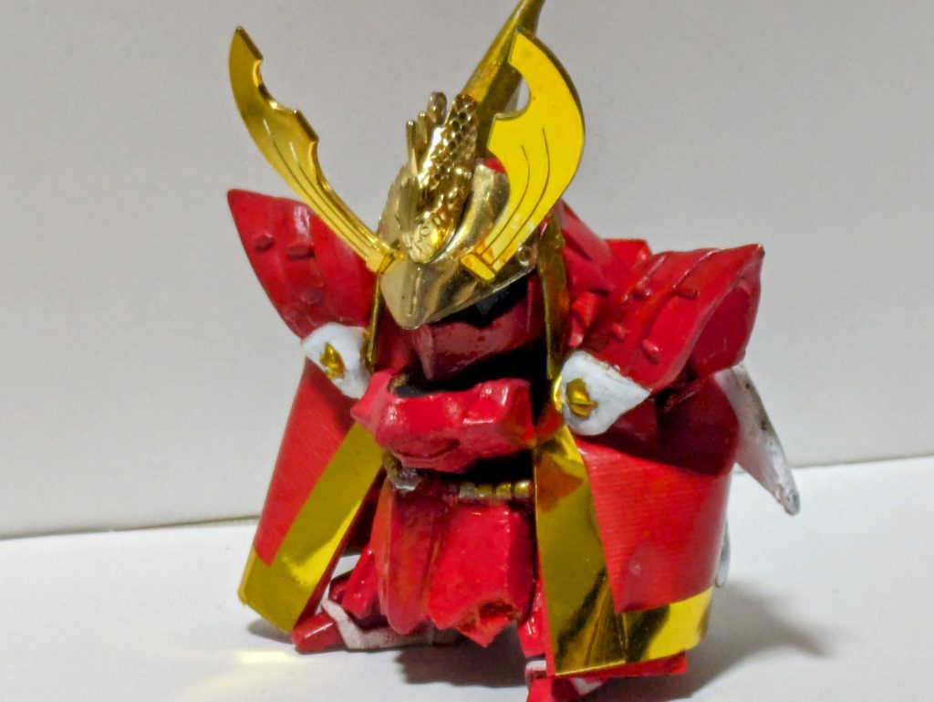 剣豪武将 漣飛威に変更したのでせっかくだからマント形態の再現を試みました。マントの材質は色々試して100均の赤の布ガムテープを重ねたものを使用しました。  金の部分はメッキシートを貼り付けました。