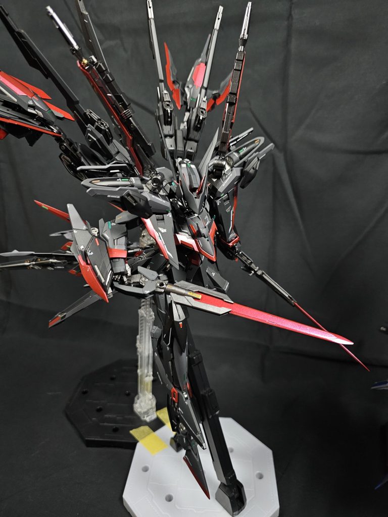 最後はそれぞれをアップで。正直それぞれを一機ずつ投稿すればよかったかなとは思ってますが、早く次を作りたくてめんどくさかったので勘弁してください。 «これ以降は機体設定です»   ADF/AGE-14を見事に撃墜した有志連合。解散し宇宙軍は正式に降伏し、軍縮条約、和平条約を締結した。  軍縮においてはお互いに保有するMSの削減や、1部兵器の禁止などである。具体的には過去に起きたADF/FX-07やADF/AGE-14などの大惨事がもう起きないよう自立型無人機の廃止し、有人機追従型無人機のみ保有が許された。他にもお互い高性能機体の保有数は大きく削減した上でEDFはADFプロジェクトを破棄。残っているガンダムは将来的には半数以下まで減らすことが決定していた。  この軍縮条約が締結された後に世界中の工場が新たに設営された監査局によって調査された。その際発覚した計画のひとつがこの機体に関する計画、プロジェクトラグナロクであった。   プロジェクトラグナロクでは、宇宙軍との最終決戦に向けて宇宙軍がガンダムに匹敵、あるいは凌駕する新型兵器を投入してくることが予想されていた(結果的にはヴァルキリー含むガンダム部隊やADF/AGE-14によって破壊された)。それに対応するため、当時ほぼ最高スペックだったADF/AGE-14FAを超える戦力を求めた。  そしていくつかの案から選ばれた最終決定案が、大型ステルス巡洋艦ヴィーズルである。この艦艇は巨大な船体と、アウトレンジ攻撃能力、MS搭載能力、ステルス性能が非常に高い艦艇として設計されている。中でも特に強力な兵器こそADF/XX-19F(M) フギンムニンである。   フギンとムニンは前述の通りヴィーズルとセットで運用が予定されており、逆にヴィーズル以外の艦艇には搭載不可能な機体である。この機体はADFプロジェクトの最後にふさわしい凄まじい戦闘力を持つ。ビットジャマーを始めとした電子戦兵装から、当時最高スペックの武装まであらゆる最新の技術を詰め込み設計された結果、一般的なMSの全長の約2倍というとてつもないサイズとなった(ヴァルキリーリビルドより少し大きい)。  しかし機動力に関しては大型ブースターなど機動性を大幅に高める兵装を装備した結果ADF/AGE-14から落ちるどころか向上しており最高スピードは1.7倍、加速性能は1.5倍というとてつもないスピードを発揮可能であった。そしてその機動性に耐えるために強度を高めた結果大型化したとも考えられている。  武装面も非常に充実しており、文字通りなんでもこなせる機体となっていた。具体的にはヴァルキリーリビルドと同じ武装や、新型の対艦ビームライフル、固定レーザー砲など幅広い武装が搭載されている。腕部の多目的戦闘ユニットによってこの巨体で格闘戦に優位に立つことも可能であった。  搭載される戦闘AIはADF/AGE-14と同じだが、そこから更にフギンとムニンの装備に合わせて調整されたもの。ADF/AGE-14とは違い2機編隊なのでお互いを支援できるような調整もされている。  ADF/XX-19の1番機のフギン、2番機のムニンはほとんど同じではあるが、機体各所に微差が見受けられる。総合的にはフギンの方が戦闘力は高いが、機動性が若干変わる程度なので大した違いはない。  実際に作られはしなかったものの、この機体の設計図の存在が発覚し、これらの情報をシュミレーションで再現したEDFの分析官によれば、ヴァルキリーリビルドどころか、ADF/AGE-14FAでもどうなるか分からないというまさしく化け物のような戦闘能力を発揮した。