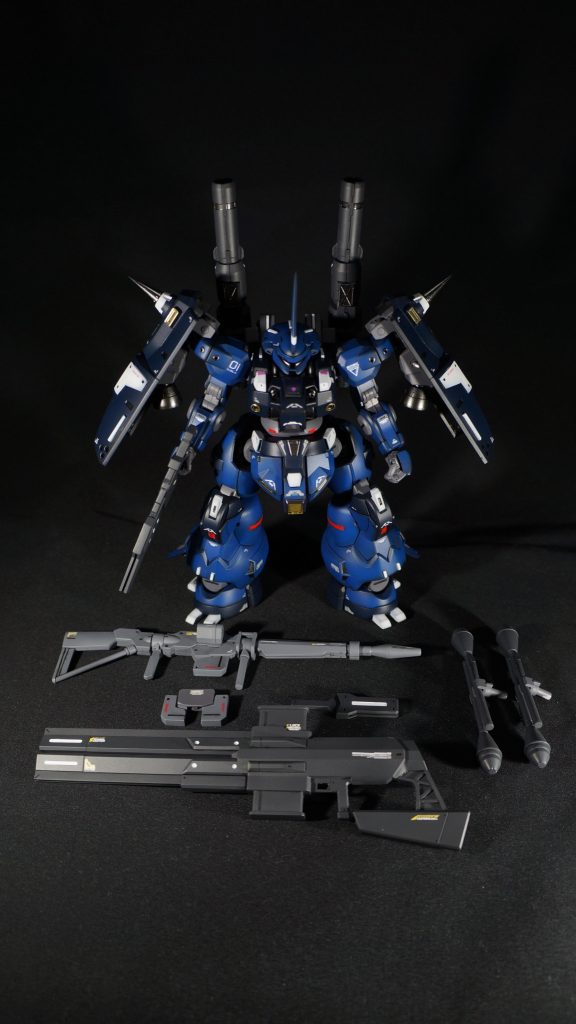 正面武装も並べてみましたが、こうすると大した量ではないですね…。このディランザ、太ましいプロポーションでいいのですが、脚が短く、足元が先細りな印象で、そこが気に入りませんでした。そこで、皆さんよくやられている股関節パーツの左右入替えで脚をちょっと延長。脚を左右5㎜ずつくらい横に出して、下半身のどっしり感を出しました。それにより腰部がスカスカになったので、白い部分を追加。太ももの上部も3㎜ほど上に伸ばして、隙間を埋めるようにしました。足元が細いのは、ケンプファーのような2本の爪をつけることで、やや足が広く見えるようになりました。また、下腿外側にバーニアを追加し、そのカバーを斜め下に伸ばすことで、末広がり感が出て、先細り感が改善されて、全体としてまとまりが出たのでないかと思います。