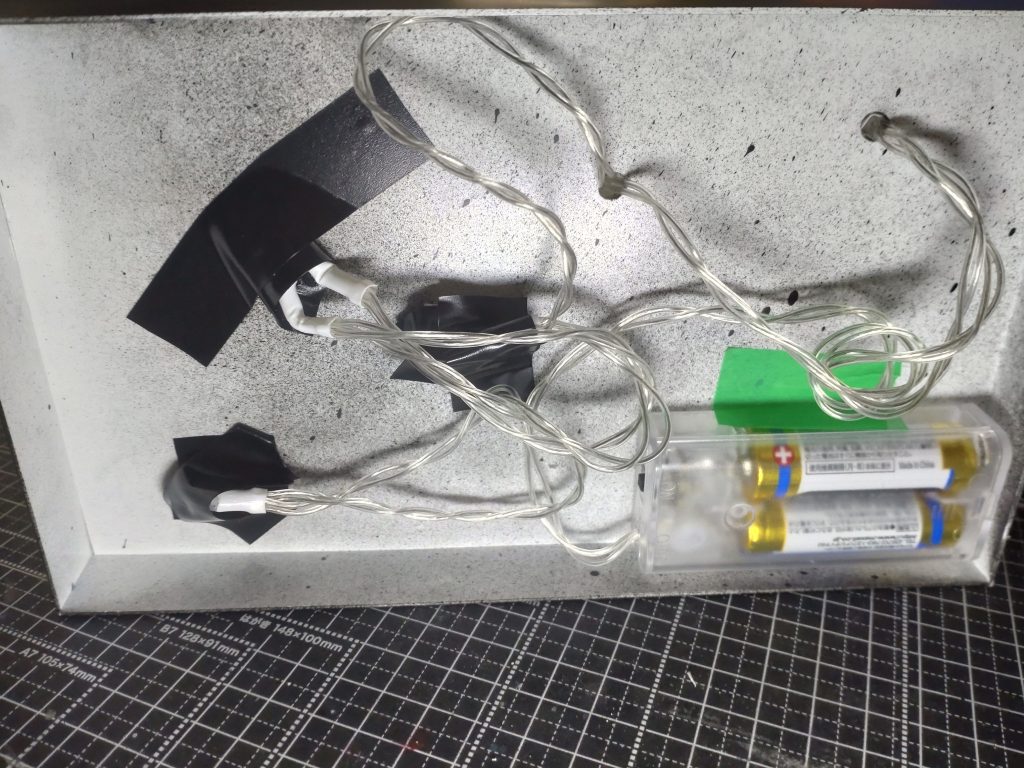 私のジオラマで度々登場する6灯100均LEDですが、今回もプラ板で作成した台座の後ろからテント内と焚き火を電飾しました。