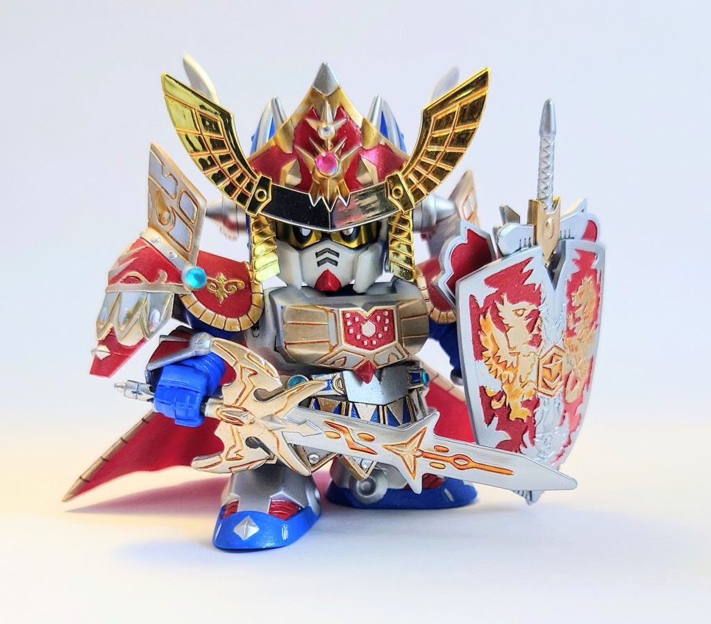 塗装は、本体白　グランプリホワイト本体青　クリアブルー＋白＋コバルトブルー赤部分　モンザレッド銀部分　スーパーファインシルバー金部分　シルバー＋ゴールドこんなところで、金部分のスミ入れはエナメルのクリアオレンジで行っています。キングガンダ厶Ⅱ世、何しろ思い入れの強いキットなのでかなり時間がかかりましたが、何とか完成です。　円卓の騎士編はドラマチックでいいよなあ。この画像は聖機兵物語で出てきた時のポーズですけどね！