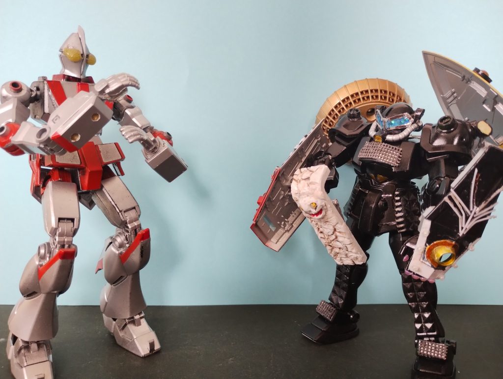 【前投稿からの続き】左手の「ゲドゥショウシンレイハ」光線でウルトラガンダムを解析したファウラス。軽装状態では危険と判断しメタバースから盾を召喚したぞ。