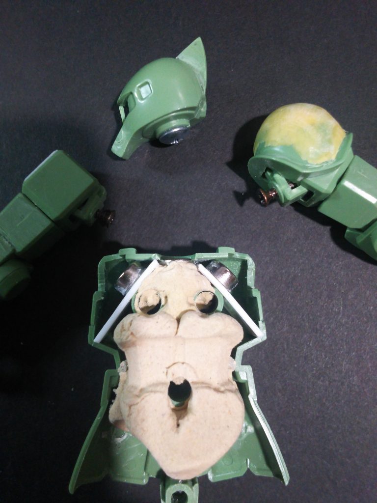 今回のキモはマグネットの仕込み。いつもはアルミ接続にするところですが今回実験的に関節にマグネットを使ったらどうか？と思ったので早速試してみました。白く見えるのはプラ板。肌色のモノは木粉粘土。ややいかり肩にするべくマグネットプラ板を斜めに設置しています。