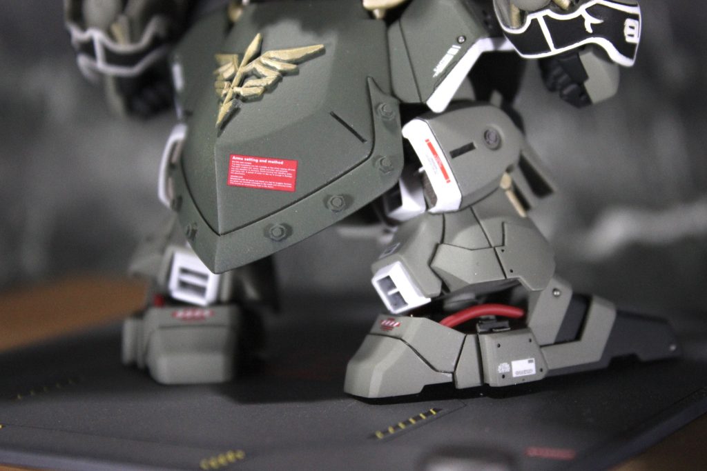 脚部後方からです。足首のところがスカスカしていたのでパイプを通しました。この位置からだとガッツリ見えますが、実際に展示しているとチラ見えくらいでちょうど良かったです。脚部後方のディテールが甘かったんでバーニアパーツを取り付けて誤魔化しています。クシャは白バーニア似合いますねぇ。スカートにはネオジオンのエンブレムを貼っています。平面ではないのでエンブレムの裏をちょっと切り、曲がるようにして根性で貼り付けました。