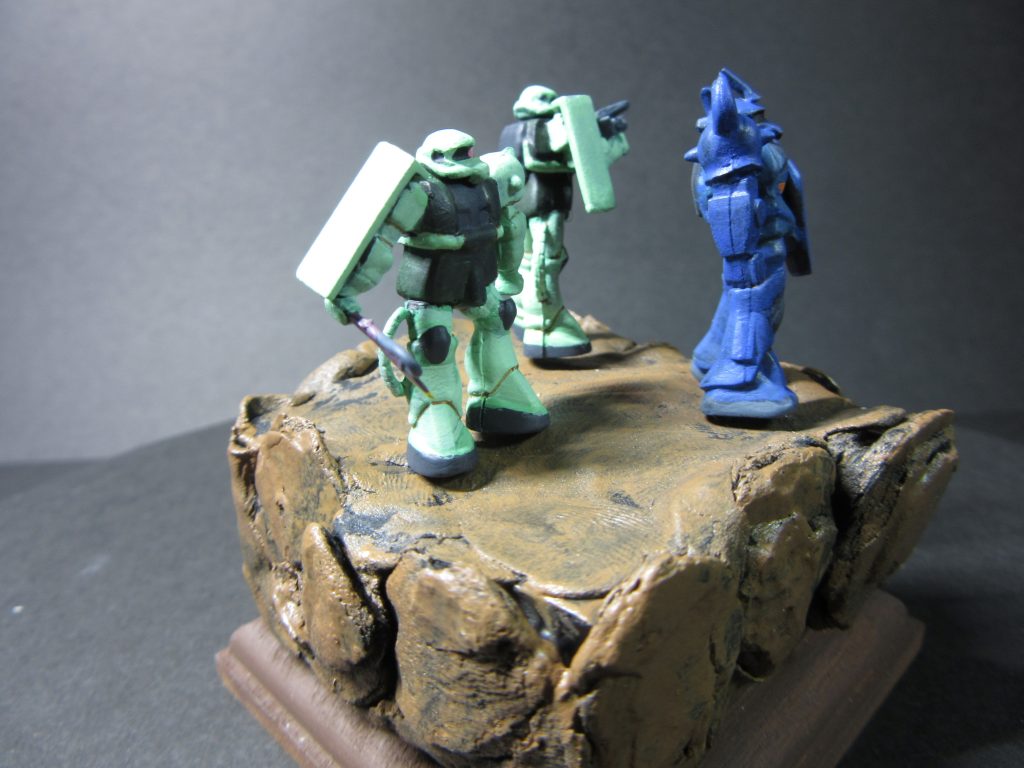 ベースはスチレンボードを四角く切り出し、それを積み重ねて木粉ねんど、園芸用チップなどを使用し、木工用ボンドで固定。塗装しています。もうちょっと高くした方が崖の雰囲気が出たような気がします。