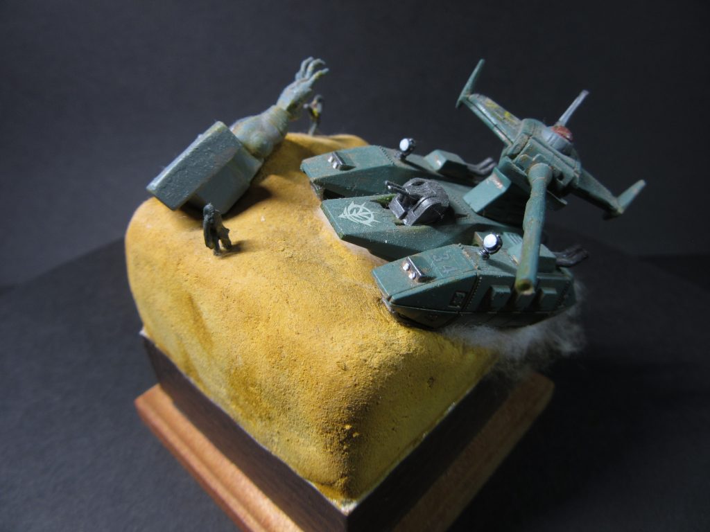 ガンプラコレクションのマゼラアタックと量産型ザクの腕部部のみ使用したビネットです。砂漠地帯での交戦の末、到着したマゼラアタック隊が見たものは破壊されたザクの腕だけだった。。。という感じです。