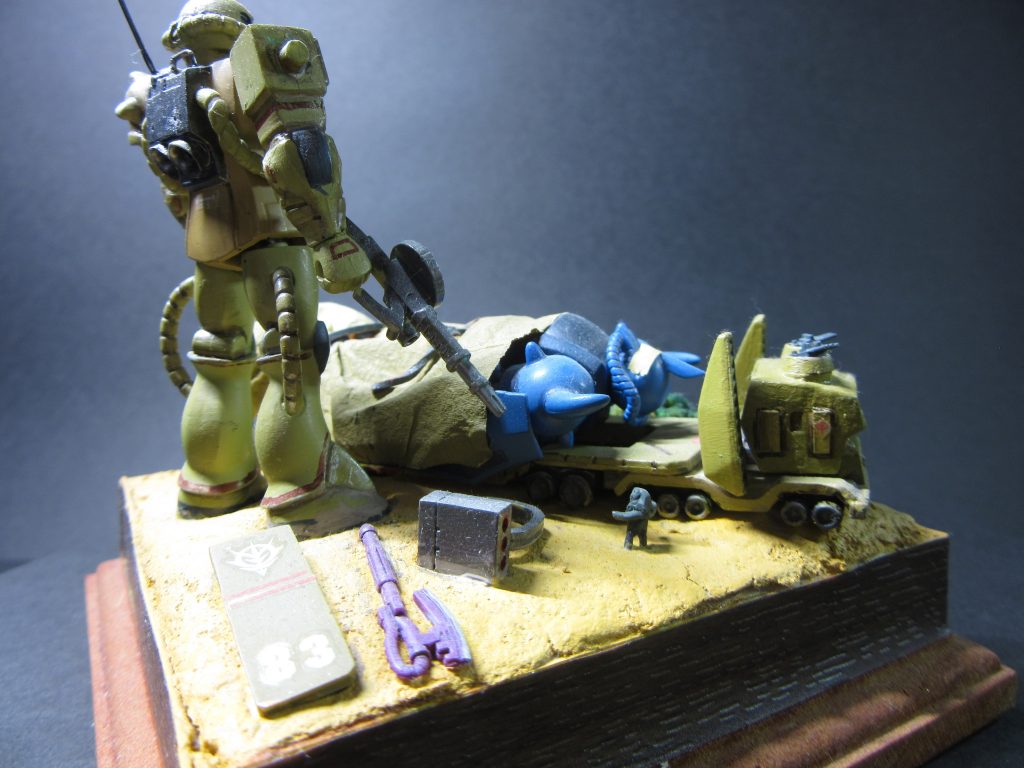 ザクはメンテナンス中のイメージでシールド。ヒートフォーク、ミサイルポッドを地面に置いています。