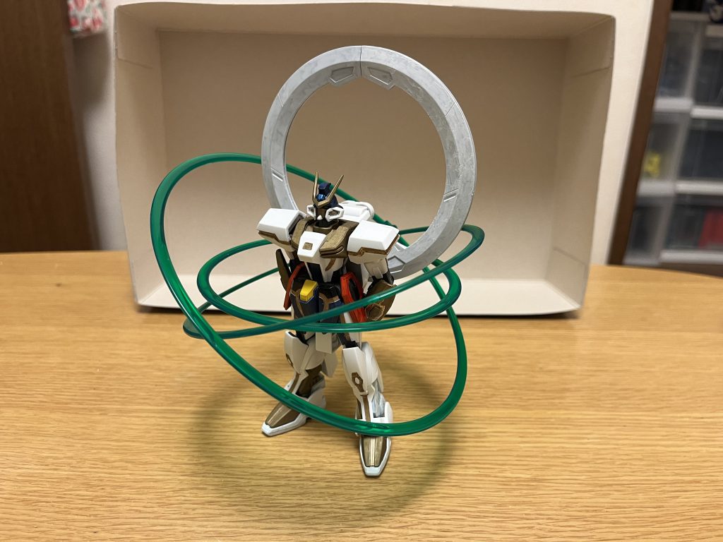特殊機能本機に搭載された独自機能であり、性能面での上位互換であるレジェンドΩ-Zにも存在しない特有のものである。アブソリュート・ブレインハッキング本機の最大の特徴の一つであり、CFH社が独自開発した外部強制洗脳装置。その仕組みは「対象のMSにハッキングプログラムを流し込み、対象のMSを強制的に支配下に置く」というものであり、さらにハッキング完了後には、MS内部のモニターを通じてパイロットをも洗脳してしまう。ハッキングの都度「対象を指定する」必要があり、一度に洗脳できる数は5体までだが、支配下に置ける数には制限は無いので、言ってしまえば「洗脳したMSという手駒が増えれば増えるほど、自動的に本機の手数が増える」という厄介な特性を持っている。ただし、特殊能力への耐性を持つMS、そしてハッキング耐性を持つMSには通用しない。さらに、仮にMSをハッキング出来たとしても(アルティメット細胞やDG細胞の有無に関わらず)、精神力が極めて強靭なパイロットに関しては洗脳できない。ドミニオン・ヴォワチュール・リュミエール本機の最大の特徴の一つであり、元々はスターゲイザーに搭載されていた惑星間航行用の推進装置。推進装置としてのみならず、強力な攻防システムとしても機能しており、リング自体も左右の多重関節アームで分割・可動させる事で、可動域の広いスラスターとして役割を果たしている。以下の機能は、いずれも地球などの重力下でも使用可能。推進装置としての機能莫大な電力供給によって、通常時ですらストライクフリーダムガンダムやデスティニーガンダムと互角以上に張り合えるほどの驚異的な加速性能を誇り、場所を問わず、本機の超スピードでの戦闘モーションを支えるのに一役買っている。また、リング自体を後部展開すれば、加速性能が一点集中する為、本体の耐久性の高さもあって、単独でも地球と宇宙空間への行き来(大気圏離脱と導入)を可能としている。ヴィジョンリングレイ原型のスターゲイザーと同様、光輪を放出する機能。この光輪自体がビームサーベルのような効果を持ち、スペースデブリやPS装甲を一撃で切り裂く威力を持つ攻撃手段になる。※念の為ですが、機動戦士ガンダムAGEの「フォトンリング・レイ」とは無関係です。デフレクトバリア本機の周囲にヴィジョンリングレイを展開し、金色のホログラムバリアを作り出す。全方位からの攻撃を防ぐ事が可能ながら、その防御力は非常に高く、核ミサイル数発の直撃をも完璧に防ぎ切るほど。また、リング自体を前方にして、その中央部にバリアを展開可能で、その状態のバリアは(その間は全方位防御できないものの)、防御面積が一転集中している為、コロニーレーザー等の戦略兵器クラスですら耐え抜くほどの防御力を誇る。ドミニオンビット光輪から小型の球状ビームを本機周囲に大量展開しつつ、それを光線として放つ等のオールレンジ攻撃を行う。このドミニオンビットの光線は、ビルどころかFT装甲をも一撃で切り裂くほどの攻撃力を有する。また、上記のデフレクトバリアを前方に展開した状態から、そこにドミニオンビットを撃ち込む事で、長距離大出力ビームを発射可能としており、その威力はコロニーレーザーに匹敵するほど。