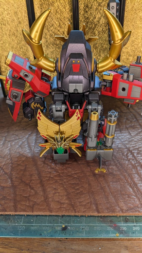 背面!ブキヤのフレームに装飾して余剰パーツを全てマウントしてみました。右のガトリングはスイングさせてそのまま武装として使えます。クリスタルフェニックスの裏にはミサイルも隠れてます。本当は角はメッキのまま使いたかったのですが、制作途中でゴミを取ろうとしたらメッキを傷つけてしまい、泣く泣く塗装する羽目に・・・。背中中央の赤いパーツはボディ側に開いてる穴を3ミリに拡張して、カットしたランナーを差し込んで裏側の凸ジョイントに差し込むことで安定した固定が出来るようになります。