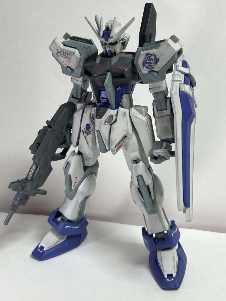 と言う事で(?)1/100のストライクです。旧キットのストライクなのです。個人的にMGやリマスターよりもコッチの方が好みのストライクなのです。異論は認めます。今回はそれを好みのカラーリングで仕上げました。ついでに改造パックとライフルもセットで。本体自体は後ハメ加工以外はほぼストレートに組み上げました。作成時のコンセプトとして、ガンダムSEEDの主人公であるご存じキラ、そしてムウやカガリと言ったメインキャラ以外の画面に映らないキャラが乗ってそうな機体と言う事を念頭に置きました。エクシードギャラクシーのカラーリングを真似つつ、青紫を使うと言う事から青い薔薇を連想→青い薔薇は自然界には無く人の手を加えたものでしか存在しない→ナチュラルとコーディネーターとの関係性から連想しました。外伝に連合に所属するコーディネーターがいた気がするけど、詳しく無いからその辺は割愛。多分薔薇が散らされたら機体が爆発四散します。