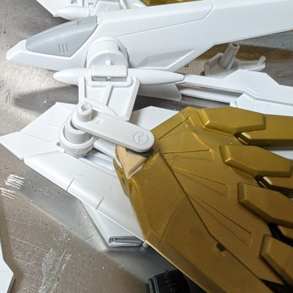 【プラウドディフェンダー】・羽根の接続部にクランク形のパーツを噛ませる・ゴールドの羽根をプラ板で延長他こまごまとプラ板を切り貼りしています。プラウドディフェンダーの羽根の工作はキービジュアルにだいぶ近いシルエットを取れるようになったので効果的だったと思います。