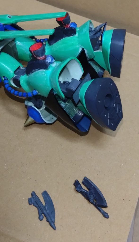 「さすがに『カードシステム』というモノは搭載されてないが、GNZは装備するモノによっても戦闘スタイルが変わる機体だ。装備無しでも十分に戦えるはずだ」「でも、私に上手くできるのでしょうか？ザクを強くしてくれたのはありがたいのですが、私はパイロットとしては素人で……」「だが、現にイクシードファイターやリベロで戦場に出向いた。今捕まってるリン・オオハナとも戦った」「偶然ですよ、助かったのは運が良かっただけで……」 パイロットとして…、なによりクロストラベラーのメンバーとして自信を失っていたニノ。そんな彼女にX(クロス)はメモリーが持っていたタブレットから別の映像を出し、それを落ち込む彼女に見せる。 「イクシードファイター、そしてリベロに残っていたデータだ。どちらもニノが操縦していた時のモノで、ここに興味深いことが明かされていた」「これは……え？」 ニノは自分の操縦時のデータに目を疑った。そこにはパイロットの技量や操縦レベル等が表示されており、ニノの場合はどれもX(クロス)やメモリー、アース程の操縦技術は無い。彼らとは程遠い数値ばかりだ。しかし、ある数値だけが全メンバーの中で一番……というより不明だったのだ。 『ニュータイプ数値:∞』 ここで周り、そして彼女自身は気づく。ニノ・ニノマエはニュータイプであると……。 しかし、X(クロス)以外に気づいていた人物が一人いた。リオである。 「知らなかったんですか？僕は初めて会った時から気づいてましたよ？」「初めて会った時から？まさか、お前もニュータイプなのか？」「いえ、僕は『スーパーパーフェクトマン』ですので」「え？何それ？」 リオは自分の正体をアースに明かす。彼がいた世界には『パーフェクトマン』と呼ばれる人種がいるが、それらを上回るであろう人種『スーパーパーフェクトマン』であると語った。 それについては別の機会に……。今はニノがニュータイプだったことである。 「データを見た時は本当に驚いた。そして本格的にGNZの開発に励んで、俺なりに開発したサイコミュを搭載した」「サイコミュ？」「欠陥部分を取り除いたことで新世代のサイコミュと呼べるモノを俺が独自で創った。しかも、この機体には全世界初めての新ファンネルを搭載。さぁ、ファンネルはどこでしょうか？」 少しクイズを出して場を和ませようとするメモリーだったが、リオがすぐに答えを出してしまう。 「脚！というより、脚の中に収納された斧型のファンネル…ですね？」 当たり前のような顔で答えるリオに『答え言うなー！』とメモリーは怒鳴り、傍で見ていたカナも持っていたと思われるピコピコハンマーでリオの背中をピコピコと叩きまくり。 「ご、ごめんなさい」