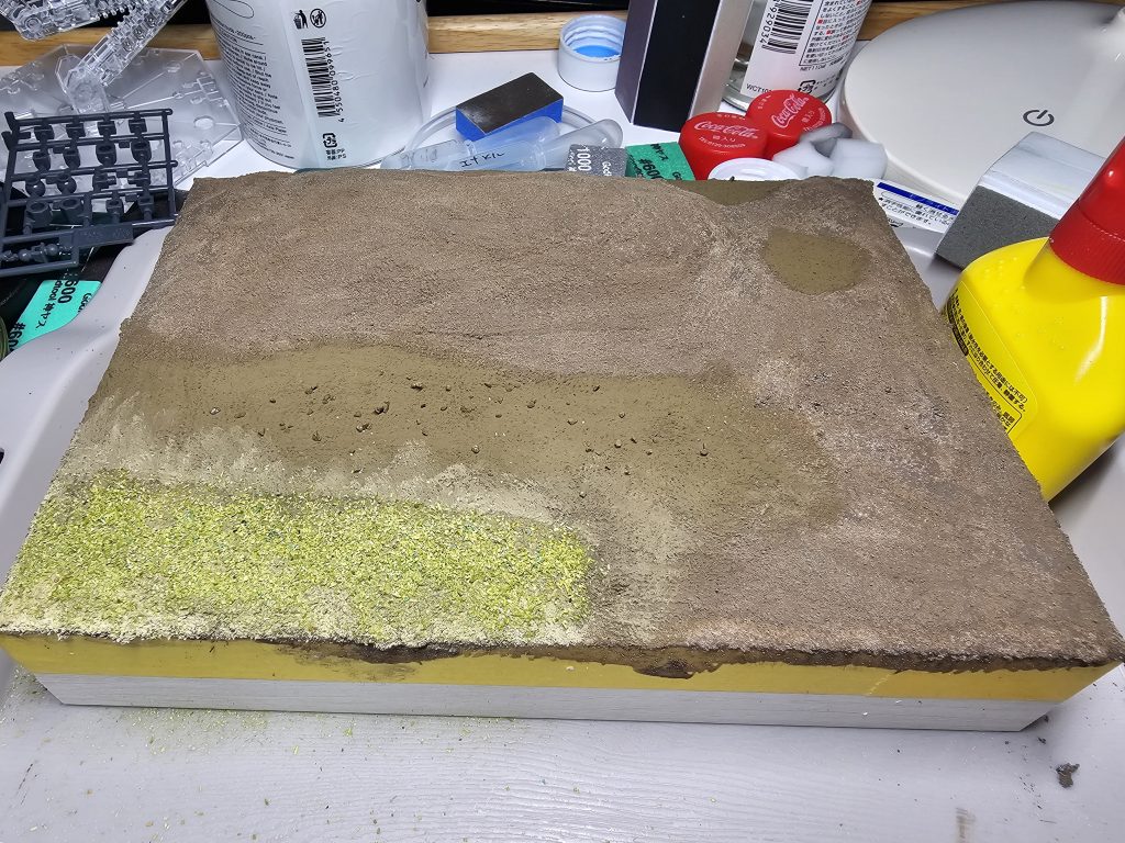 ジオラマベースは百均のフォトフレームに百均の紙粘土を貼り、タミヤの情景テクスチャとクレオスのウェザリングペーストで色分けをして、百均の草原パウダーを撒いたら完成土感の境目が非常に難しいので次はもうちょっと自然にできるようにしたい