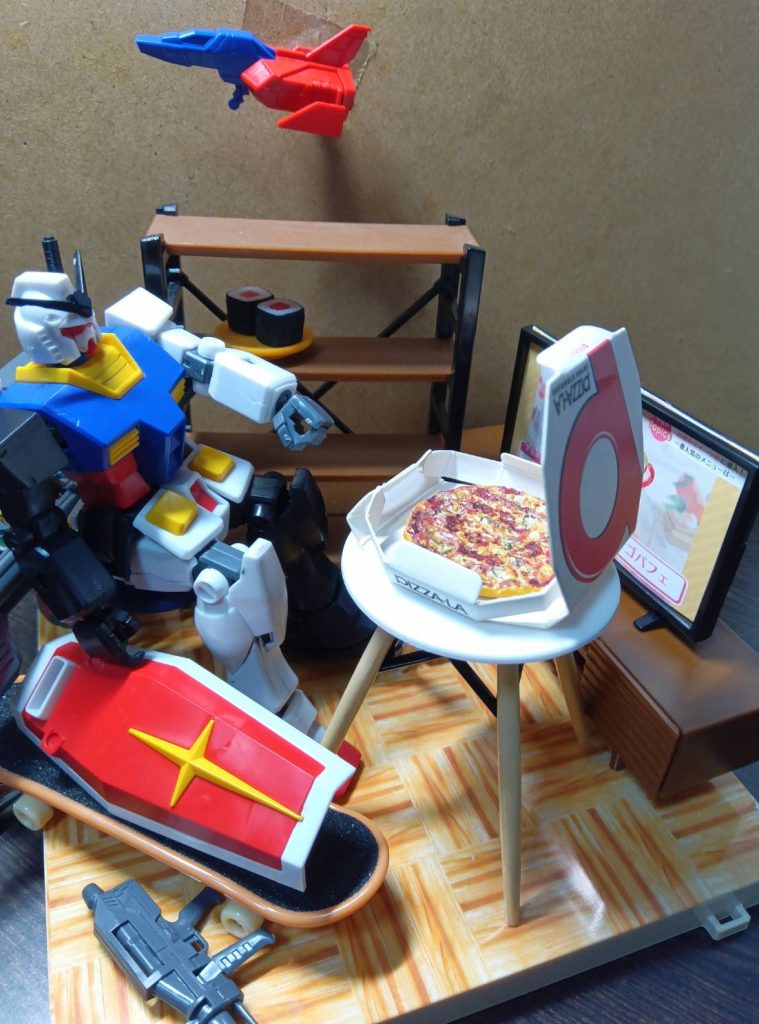 コアファイターを部屋に飾り、スケボー趣味のガンダムさん 寿司とピザで豪勢な食事です