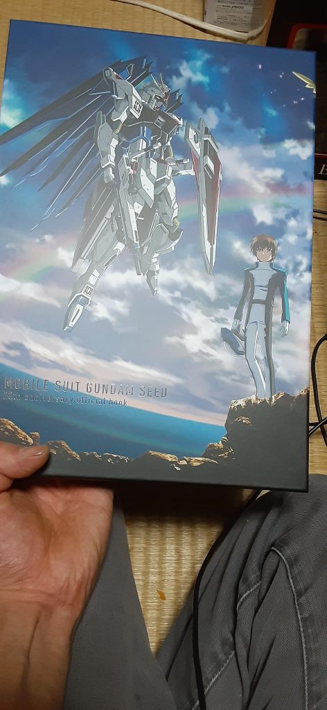さて、恐らくSEEDファンならもうゲットしているでしょう20周年記念ブック。1万以上の価値どころでない内容…‼️これまで色んなとこ、プロモーションとかで使われた色んなイラスト、しかも色んなイラストレーターの方のもあって見ながら泣きそうになりました。中には「え⁉️」てなるイラストもあり、キラ君を真ん中にして両サイドにウェディングドレスのラクスとフレイがいるイラストには苦笑いしました😅
