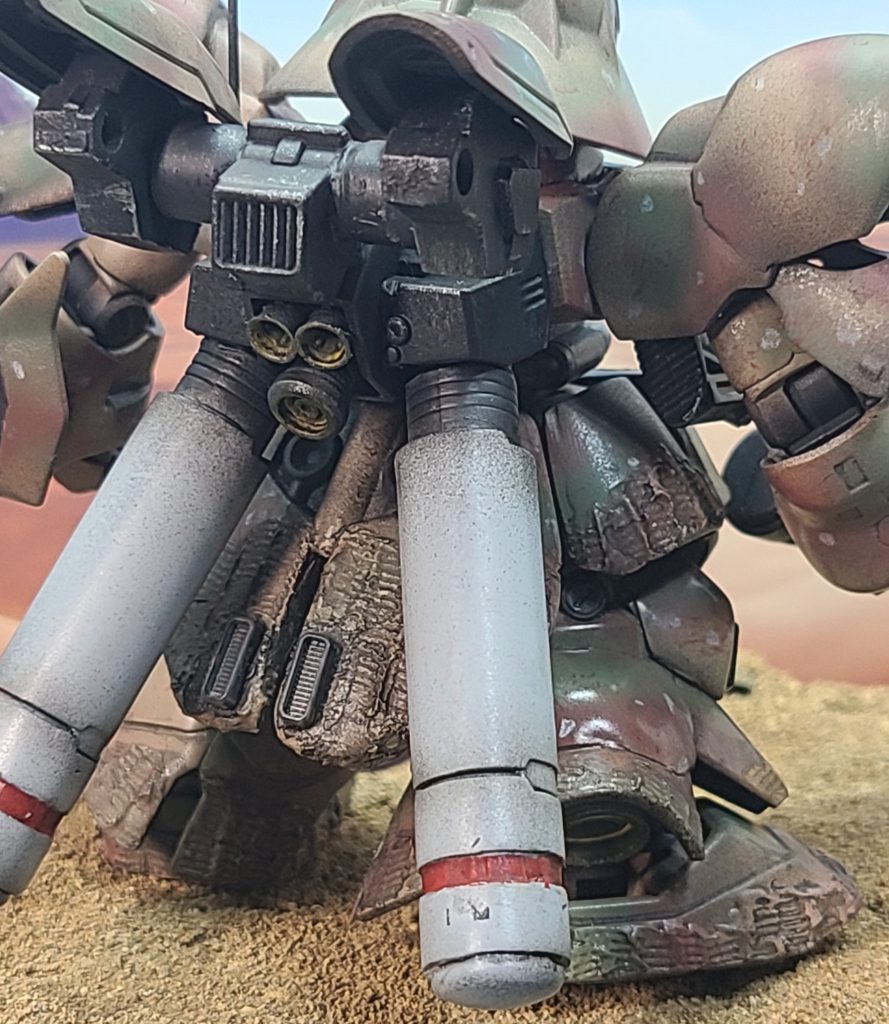 いきなりバックショットで失礼します😅後ろ姿の資料があまり見つけられず、想像で補完してあるので完全再現とはなりませんが、なかなかうまくまとめられたと思います。ファンネルラックは排除して、市販のパーツを取り付け、スタビライザーのように。左右可動します。プロペラントタンクも市販のものに置き換えています。イラストに準じてロッドアンテナも取り付けました。イラストだとタンクも迷彩もしくはサンドカラーのようですが、メリハリを付けるため別の色にしました。