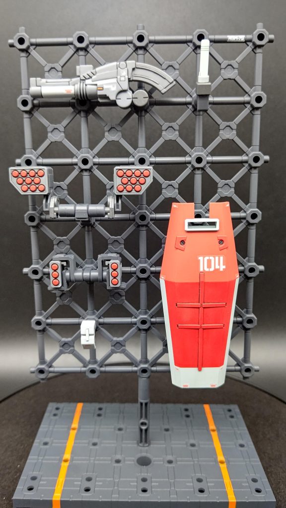 それぞれハンガーをアップ。ビーム兵器の放熱部(と思われるパーツ)やバズーカ、ミサイルの後方噴射口など、高熱になる箇所をメタリックで。アクセントのオレンジが意外といい感じ。 ハンガーは逆にあまり目立たないよう単色で塗装、スミ入れも未実施です。台座は格納庫をイメージしてラインを引いてます。