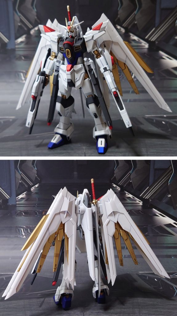 マイティーストライクフリーダムの前後ろ。工作は、ゲート痕処理、エッジ尖らせ、パーティングライン・段ズレ・ヒケの対処、面出し、首裏とプラウドディフェンダー翼基部の肉抜き穴埋め、市販パーツ貼り付け・埋め込みによるディティールアップを実施。手首は30MMオプションセットに差し替え。色については大きな変更をせず、暗め濃い目のつや消しメタリック+若干の(手抜き含む)アレンジ。金色部分は手持ちのゴールド3種を全て使って塗り分けました。