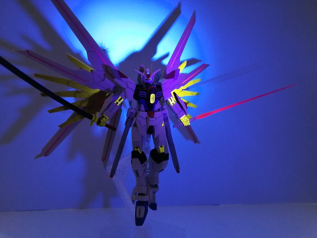 UVライト撮影。ツインアイ・頭部カメラ・ビームサーベル等は蛍光カラーで塗装したので、発光します。プラウドディフェンダー等のゴールドパーツはもともと発光します。