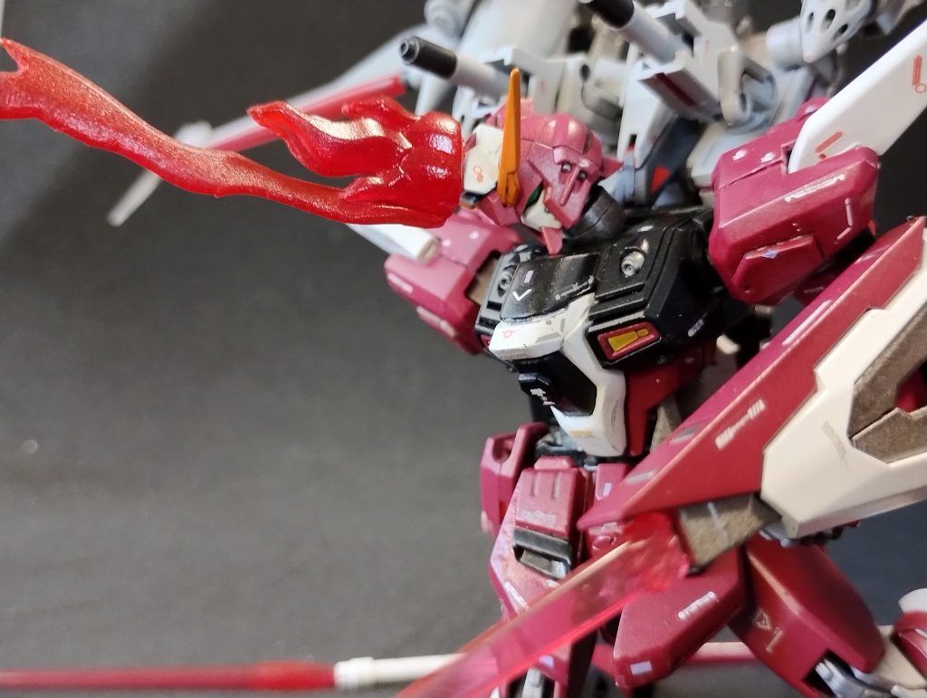 頭部ビームソード!!!!なんで頭からビームだそうとしたんだろう…まあアスランだしなぁ…クリア成形のエフェクトパーツを切って貼って削って、クリアレッドを吹きました。「色濃すぎるか?」とも思ってたんですが、あの迫力だすんならこれくらい個性強いほうがいいかもしれぬです。エフェクトパーツの重量がそれなりになってしまったため、これつけると頭がカックンカックンなってしまうため、首関節はボールジョイントで再構成しました。これによって見栄えのために首を伸ばすこともできる上、深くうつむいたりできるようになりました。 HGCEのインフィニットジャスティスと、弐式の大きなデサイン差は腰アーマー(そもそもダクト位置が違う前部・サイズが違う横部)や肩部などにあると思っています。これらは正確ではないですが、ある程度盛り込めたのではないかな??と自画自賛。