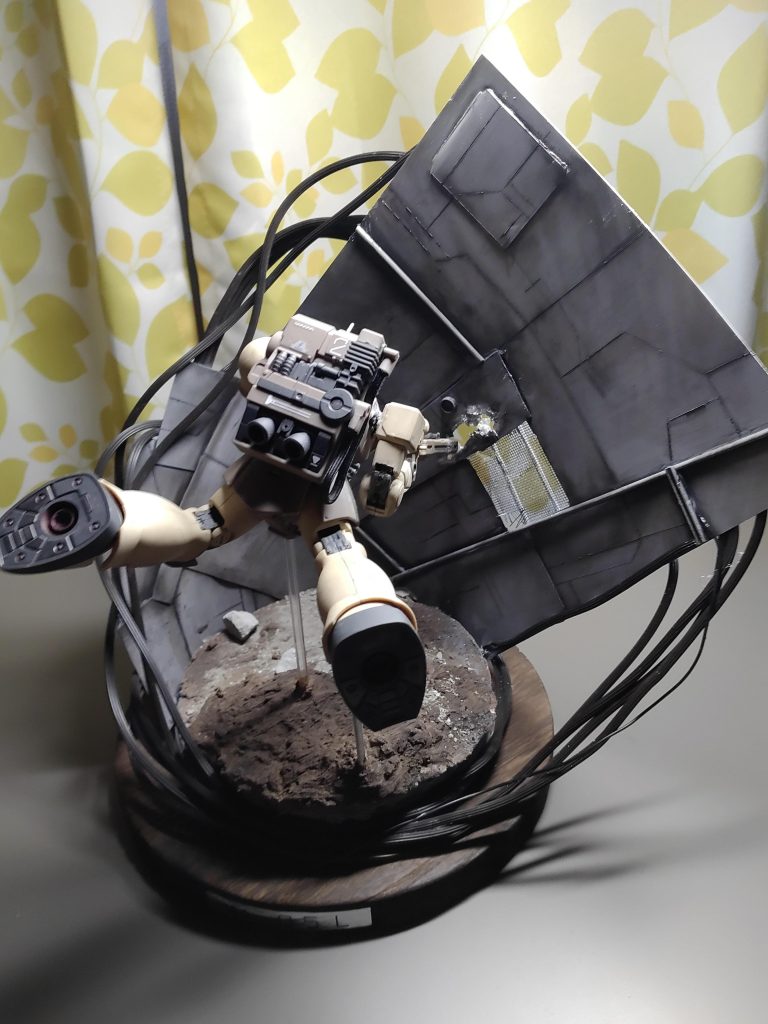 斜めからの写真です。見えにくいですが銃口が壁に刺さっています。これはどうしても浮かせるには3つの支柱がないと厳しかったので苦肉の策で銃口を壁にさしました。無理やり理由付けするなら、何発も撃ったあとの銃口はとても熱くなっていると思うので降下の際、少し掠っただけで溶かしてしまった。などはどうでしょう(gundam-kao5)