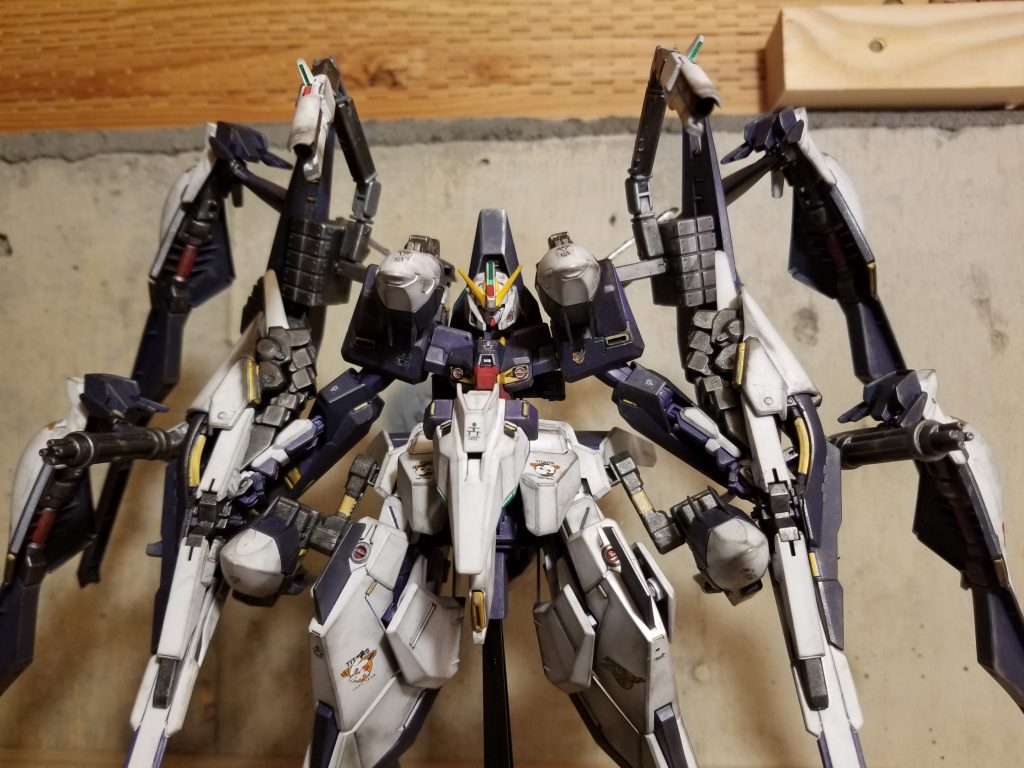 コンポジットシールドブースター2機、ウインチキャノン4機による攻防一体のオールレンジ攻撃に加えて、両肩サブアームによるメガ粒子砲&ハイパービームサーベルで近接格闘に対応。ミサイルポッドやガトリングガンなどの実弾兵器も搭載。強化人間2人乗りプラス強化人間OSによって、驚異的な性能を発揮する。