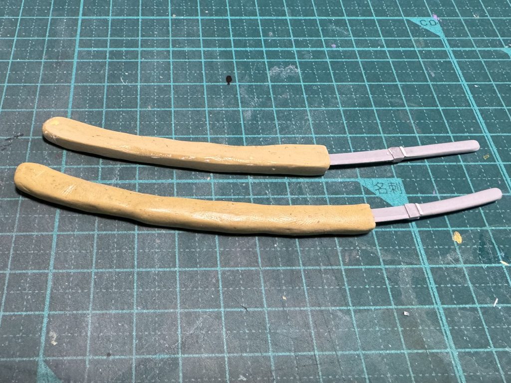 侍風なんだから日本刀装備は必須だろ!となり自作しました(本体より時間かかったあげく満足してない)打刀・脇差の大小のイメージでいたのに、実際には大太刀・太刀くらいのサイズがありそう(太刀なら差し方違うとか言わない)MSで居合とかしないだろうし、ケレン味は増したのでヨシだろそもそも鞘なんかいらない気もするが、そこは雰囲気重視でさ!(きっと東方文化(宇宙規模の東方って?)かぶれのメカニックがやったんだよ)