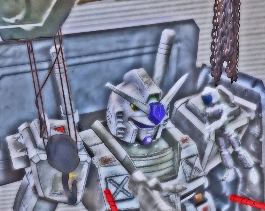 「ガンダム実弾装填終わってる!?」「バルカンのカートリッジは交換済みです！」「よし！ビームライフルも実戦用に再調整はできてるわね!?」「もちろんです！」「そっちの貴方！スラスター系チェックの報告はどうしたの⁉」「まだ確認中ですっ！」「急がせてっ！」1人のメカニックが各方面に目をやりながら素早く指示を出し、その場を仕切る。そんな中、ノーマルスーツに身を包んだチェスターとゼノが格納庫に入って来た。高さのある格納庫のキャットウォークから現れた2人は手摺りを蹴ると、その反動で床まで流れるように身を任せる。「みんな慌しいですね」「そりゃそうだろ。いきなり戦闘配置につけだからな」「この艦、評価試験隊の筈なのに前線に出ろなんて」「どうした、怖気づいてるのか？」「そんなんじゃっ！」「現場にいる以上は安全な場所なんてないぞ！」「分かってますよ」