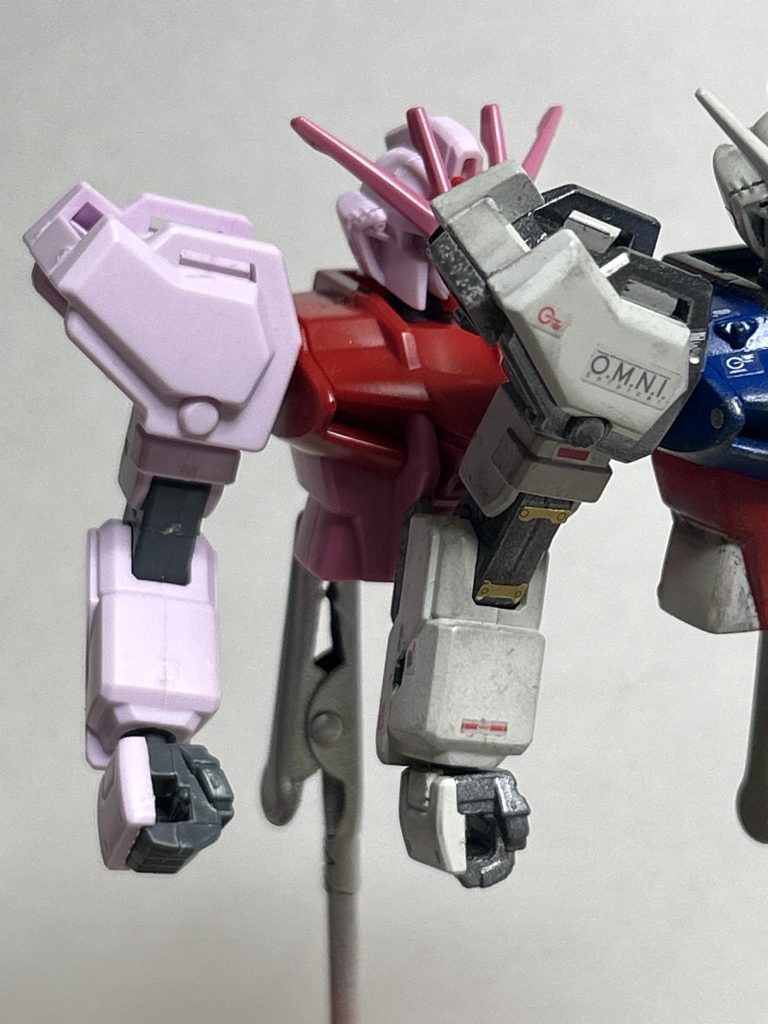 『言葉見つけられず　思わず触れた肩先』肩は、旧HGの物は大き過ぎると感じた為にEGの物をつける事ができるように良い感じに加工、グレードアップパーツでリマスターインスパイアのスラスタダクトを追加。劇中、突撃している時の回避行動の際にこの辺から光が出てるようにしか見えないからってのもあります。腕は関節のカッターで掘り込む事でのディテールアップと、前腕部と一体成形の肘のウェポンラックを削り代わりにHGCEの物を加工して取り付け。これで3ミリジョイントとして活用できます。……大して使わないけど。手首はEG。以下備忘録。次に同じように作る時は、肘との接続部側の前腕部はもっと上下に装着されていると言った別パーツ感を筋彫り等でもっと出した方がいいかも？肩関節と胴体にボールジョイントを仕込んだ方がポージングの幅が広がるかも？以上備忘録終わり。