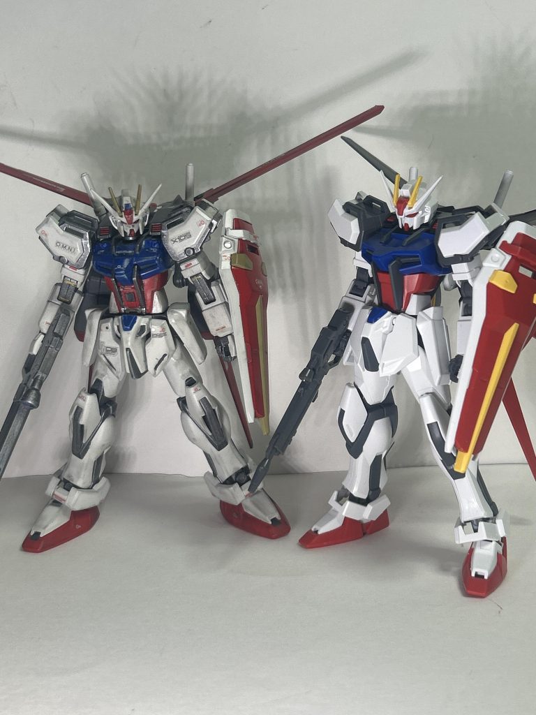 『今の君に映る宇宙は　どんな色なの？』急遽手に入ったHGCE版と。体型のバランスが全然違う……。というより4ミリ伸ばしてなおHGCEの方が大きいのか……果たしてHGが小さかったのか、それともHGCEが大きいのか……。互いに殴り合ったら今回作った方が絶対に強いな！(？)。と言う自画自賛。カラーリングは、落ち着いた感じにしたかったので明度を落としたチョイス。少しくすんだ感じな理由としては、前述通り砂漠の虎あたりのストライクガンダムのイメージ……その時のキラ君は色んな意味でもう純粋な少年じゃなくなってる(重要)ワケなので……。それはさておき、白はインシグニアホワイト。青はブリリアントブルー。赤はブライトマイカレッド。黄はダークイエロー。フレーム等はライトガンメタル。エールストライカーはグレイバイオレット。そしていつものウェザリングマスターで汚し、つや消しです。デカールはRGのテトロンシールをそのまま使用しました。以下備忘録。 テトロンシールを使う場合はつや消しの順序を間違えないようにすべき。以上備忘録終わり。