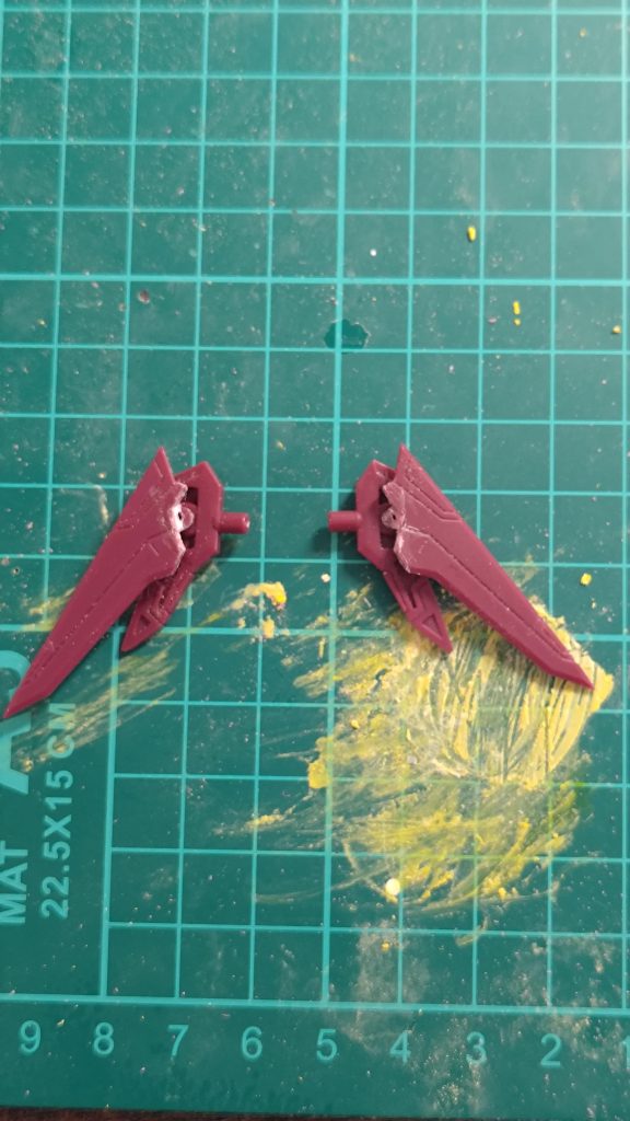 バックパックの改造2。カットしたパーツの左右を入れ替えてカット前のパーツの3mm穴に差し込みます。これでウイングが展開できるようになります。