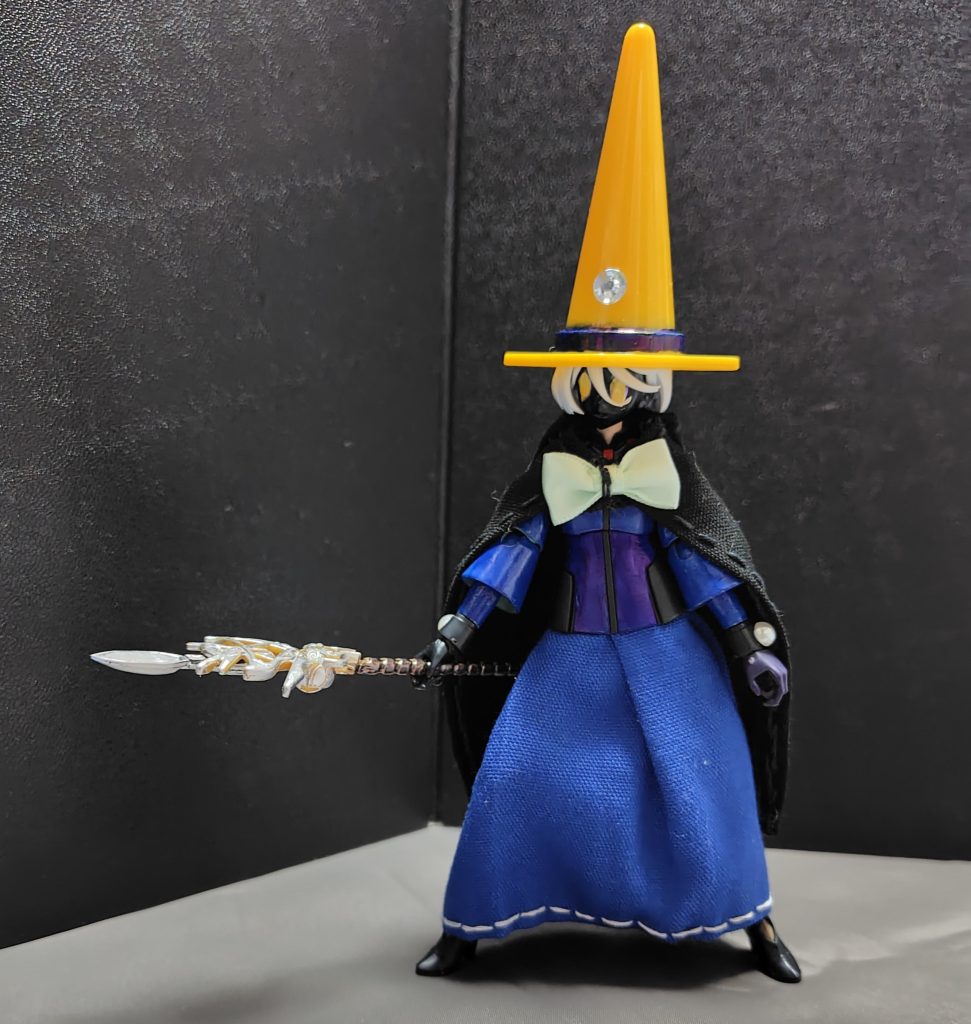 今回の制服構成は、ベースはアスティカシア学園の制服で、そこにロングスカートとマント、それからとんがり帽子を用意する事で黒魔道士風に再現してみました。・スカートやマントの生地は以前に作ったメイド服のより少し厚めの素材を使用しています。・とんがり帽子は百均ショップで購入したミニチュアのカラーコーンを流用しています。内部を少し削るなどの加工をして、あとは両面テープを貼ることで被らせる事ができるようにしています。・腕や帽子についている装飾品は、これも百均(セリア)で購入したデコレーションシールを利用しています。