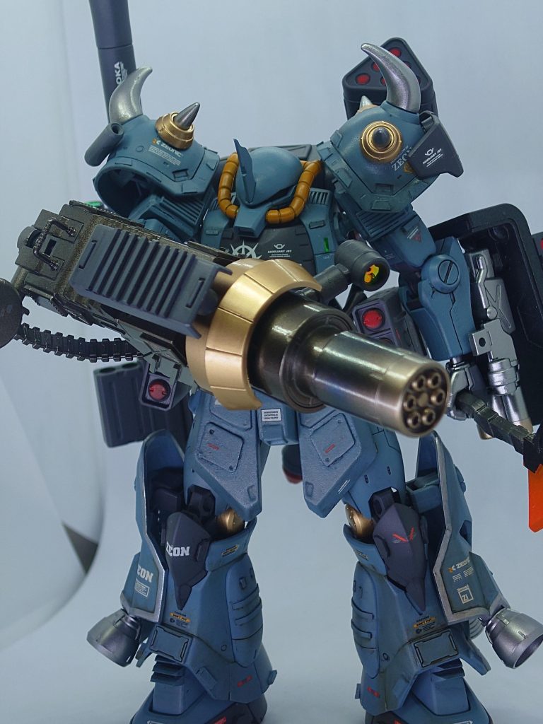 75mm ヘヴィガトリングユニット  グフカスタムのガトリングシールドと共通のマガジンを有するガトリング。こちらは独自の内部機構によって火力強化が図られたモデルだが、反動も高く精度に難のある武装として試験機の粋を出なかったとされる。しかし実戦運用の結果は良好であり、複数の敵機を弾幕で圧倒する優秀な武装と評価された。またシールド装甲部分の強度は極めて高く、外部からの衝撃に強い特殊合金が用いられている。耐弾能力はルナチタニウム合金にも劣らないという。