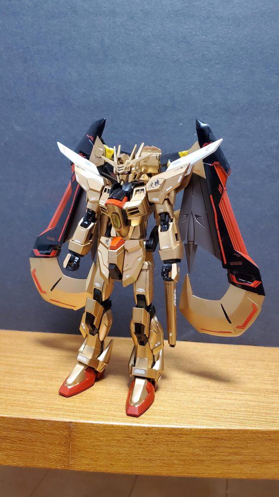 開発経緯①:ファウンデーションによるレクイエムの照射を防いだアカツキ。しかし、その後アカツキの外装は一見無傷に見えるが実際のところ上半身(とくに胸部、前腕部)がレクイエムの照射により焼けだだれており、ヤタノカガミ特有のビームを拡散・反射能はほぼ失われていた。