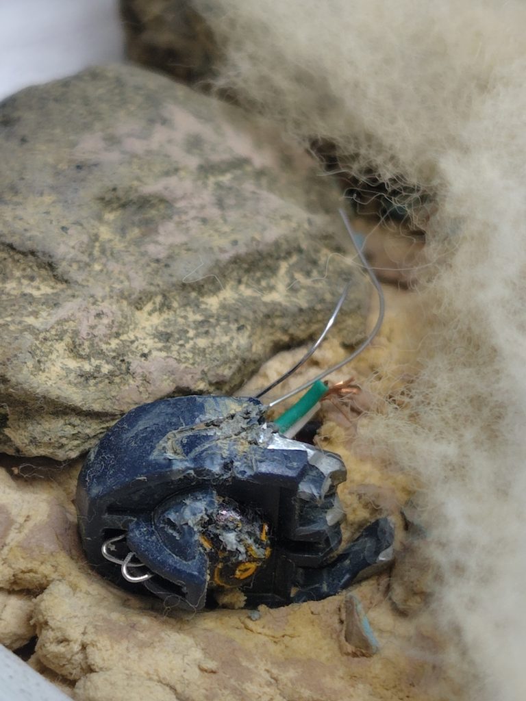 端のほうに頭部を殴られて撃破されたであろうグレイズの頭部を配置しました。カメラ部分などを削りつつ、針金と100均の充電コードで内部メカが露出している風にしました。