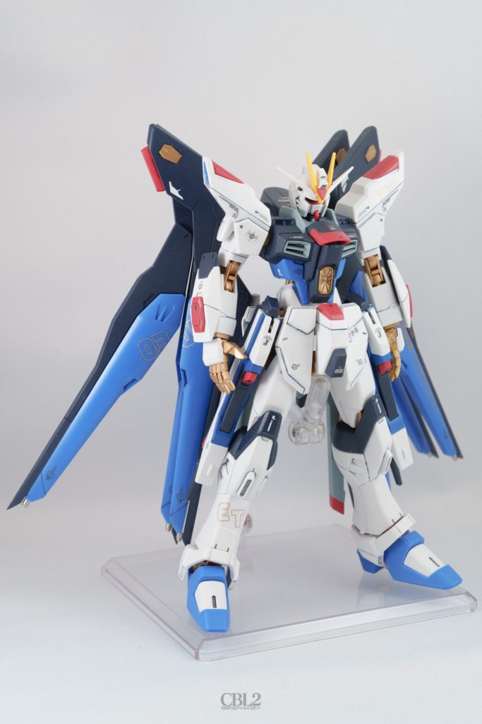 金色のフレームはガンダムマーカーのレッドゴールドをエアブラシシステムで吹き付け、光沢トップコートで仕上げています。そのほかの装甲はつや消しトップコート。メリハリが出るかなって思ったんですがどうでしょうか。レールガンを後ろに回して、腰横にビームライフルを装着するギミック気に入ってるんですが、弍式ではオミットされてましたね…悲しいんで、今回のストフリでは腰にビームライフルをつけた状態が一番かっこよくなるようにしようと思いました。キットのダボピンを切り飛ばして、ネオジム磁石でくっつくようにしました。取り付け位置を少し下げたので、窮屈感がなくなったと思います。腰の軸も延長してS字立ちを強調してみました。バックパックの重みに負けがちです。