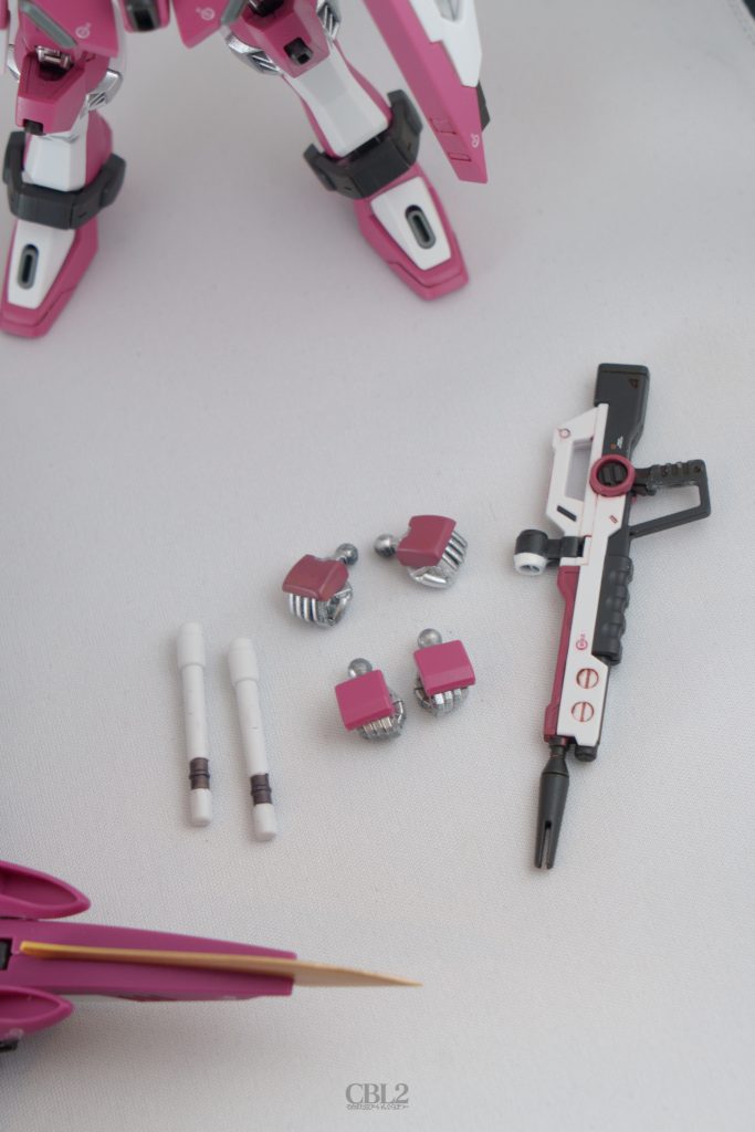 ビームサーベルグリップとハンドパーツ、ビームライフルです。グリップの穴には前述の通りゼムクリップを仕込んだので、ランナータグの切れ端で穴を塞いでいます。ハンドパーツはキットのパーツの他に、ビルドナックルズ（丸）の握り手を用意しています。甲を平たく加工してガンダムマーカーシャアピンク2で塗ったのですが違和感ないでしょうか…？ビームライフルは塗り分けしました。腰への取り付けピンの位置がライフルの後方だったので、腰に取り付けた際にバランスが悪く感じました。これもピンを切り飛ばしてライフルの中心あたり（ちょうどセンサーのヒンジの下あたり）にネオジム磁石を仕込んでいます。