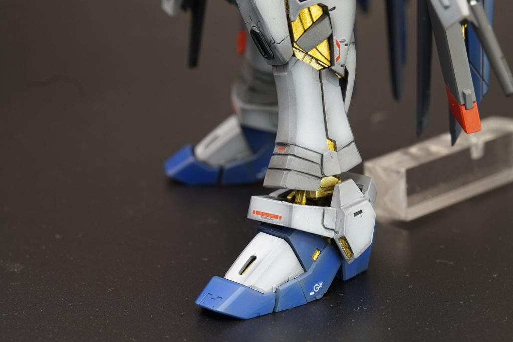足は3mmほど延長しました。延長に伴って脛の外装パーツを延長工作していますが、前作ほどの取って付けた感のないように仕上げてみました。くるぶしアーマーにも関節隠しの延長工作をしています。爪先は少しスリッパが浮くように取付、フレームがほんのり覗くようにしています。あと、ホントに目立たないところですが脹脛裏のスラスターカバーも3mm延長しています。
